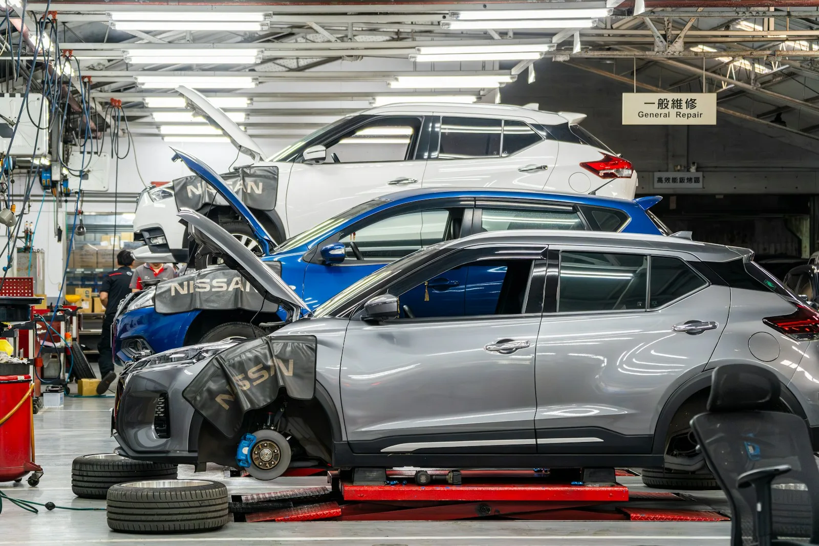 Vehicles raised on lifts inside a clean automotive repair workshop