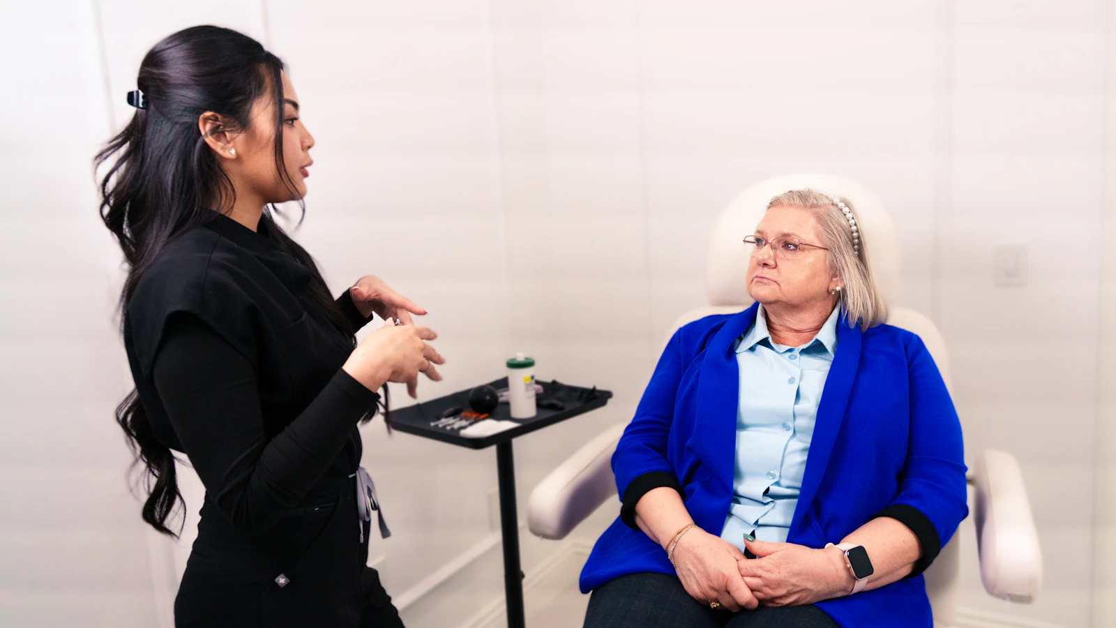 Two people speaking in a clinic room.