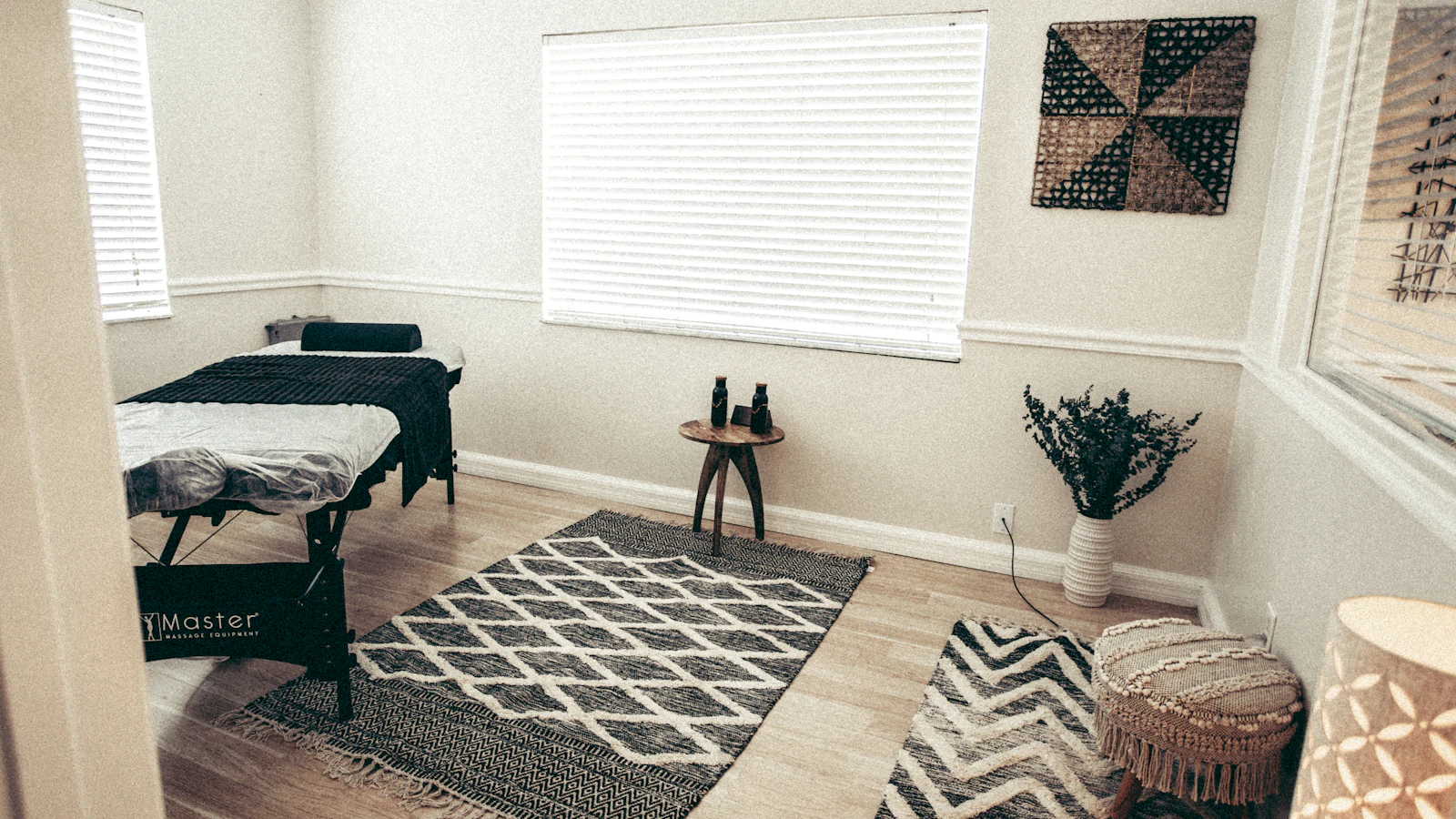 A massage table and a rug in a bright treatment room.