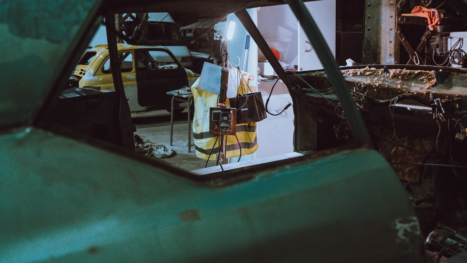A stripped vehicle body inside a restoration workshop.