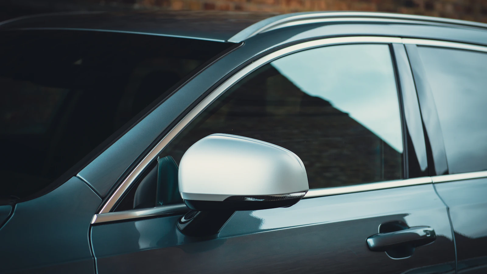The side windows and mirror of a gray vehicle.
