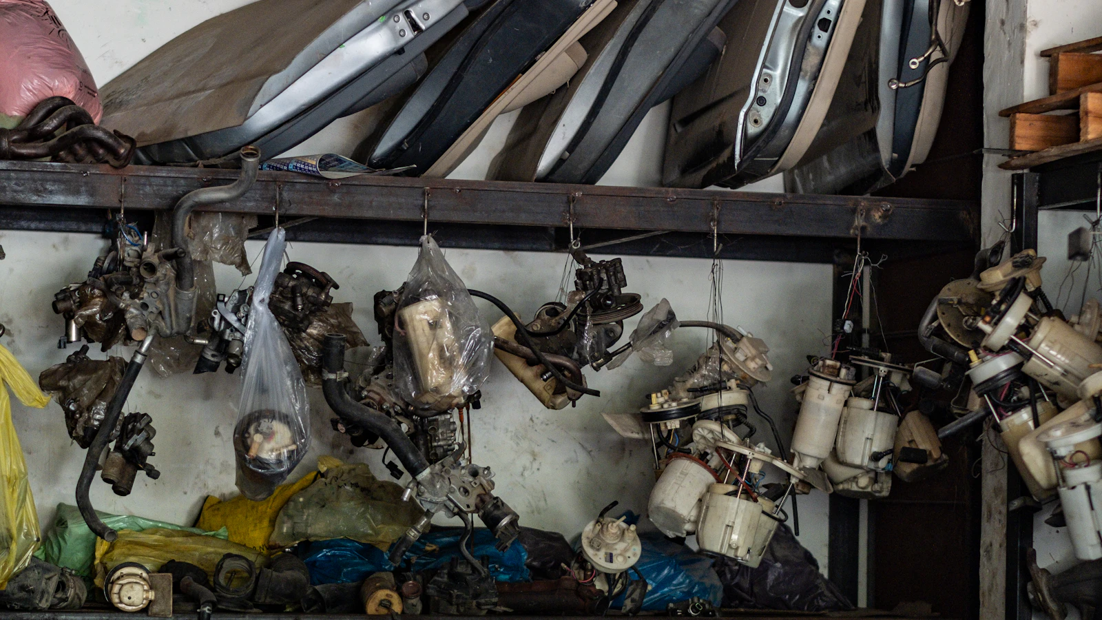 Automotive components and metal parts stored across a workshop wall.