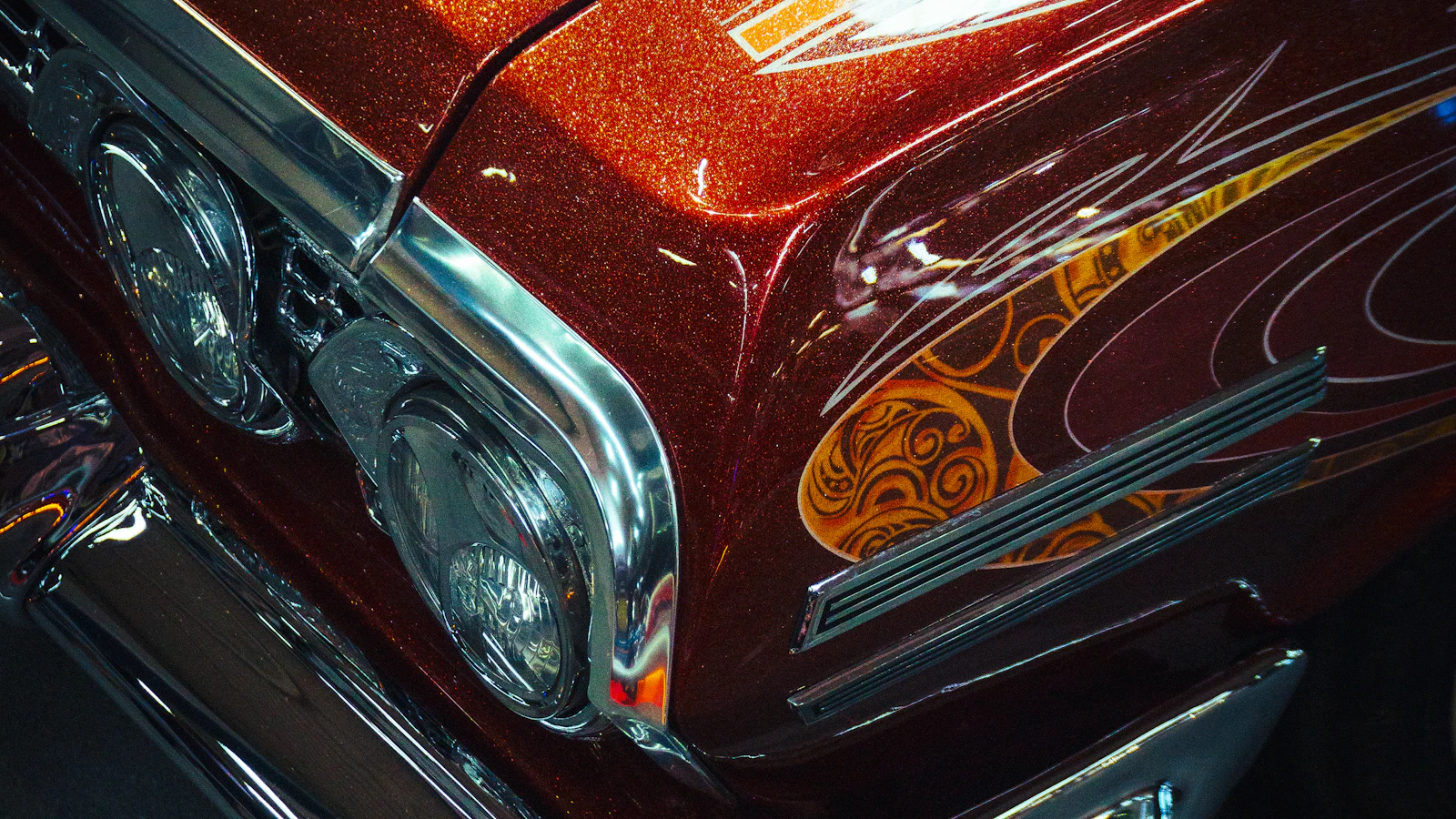 The front of a classic car with a detailed metallic custom paint finish.