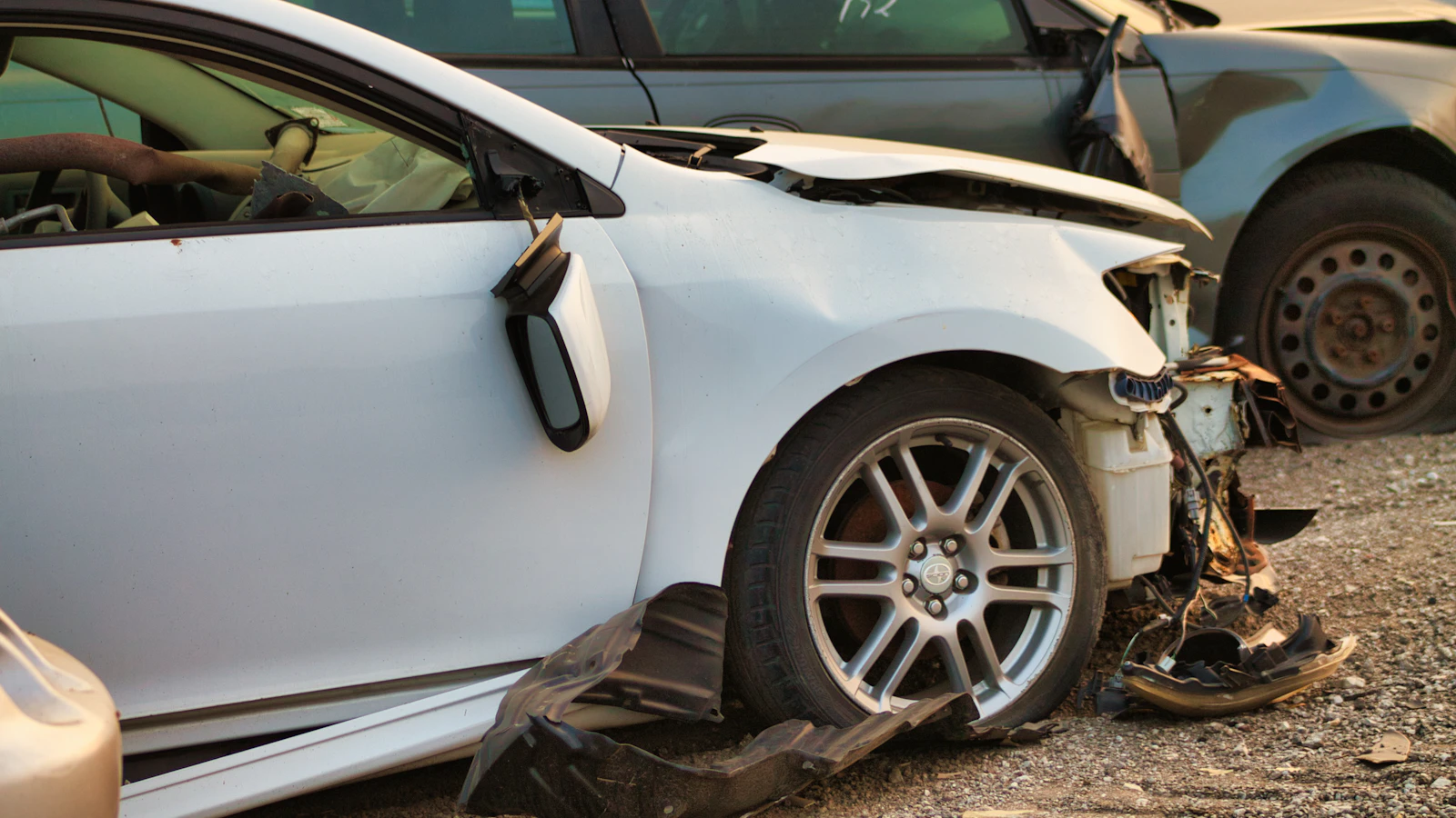 A white vehicle with visible front-end collision damage.