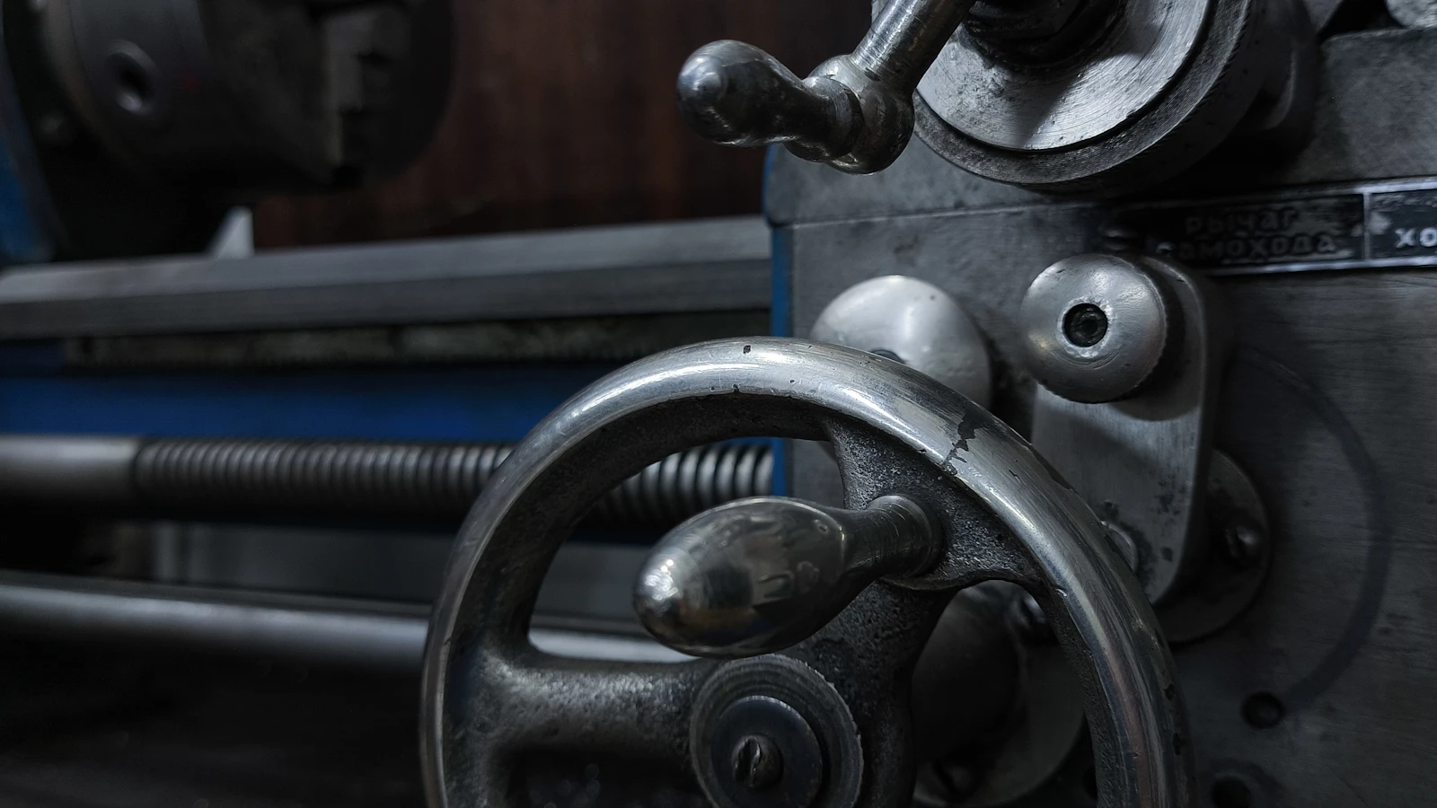 Metal handwheels and controls on an industrial machine.