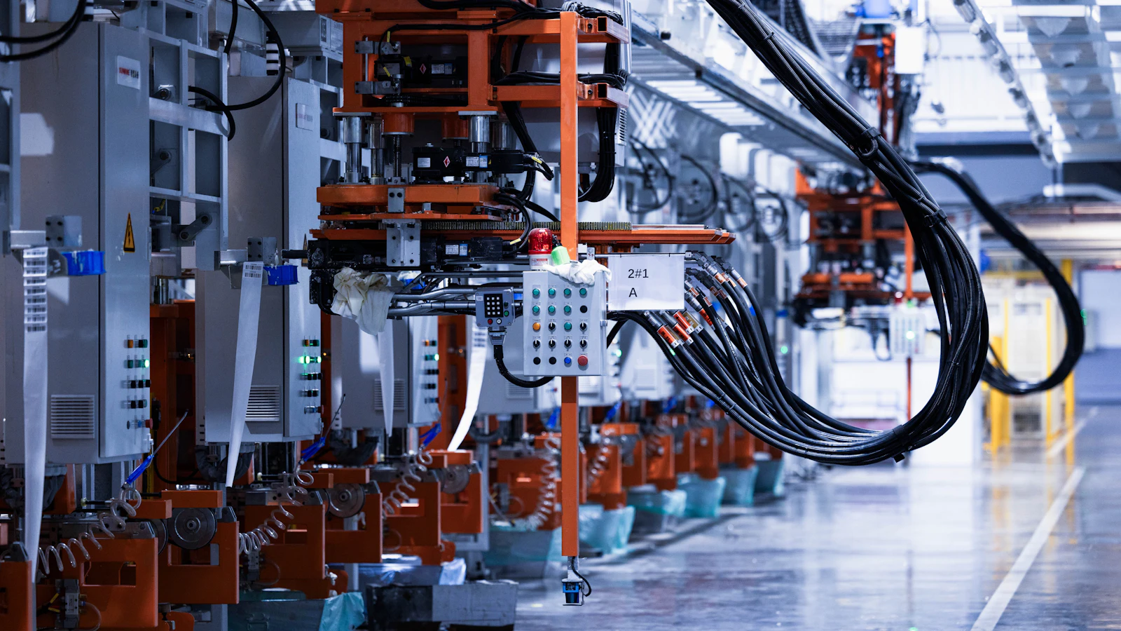 Industrial production equipment and cables along a factory line.