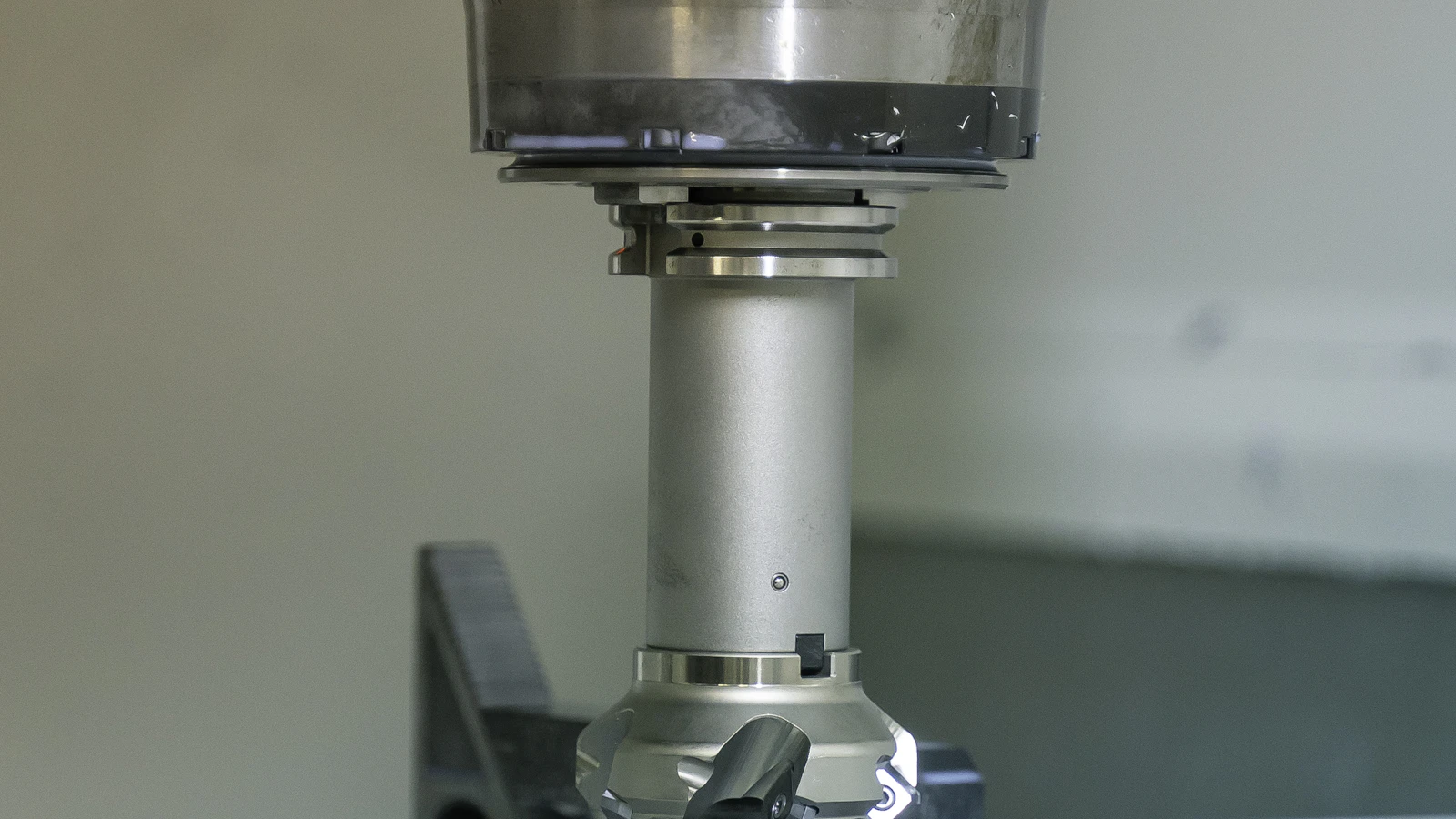 A machine spindle positioned above a metal component.