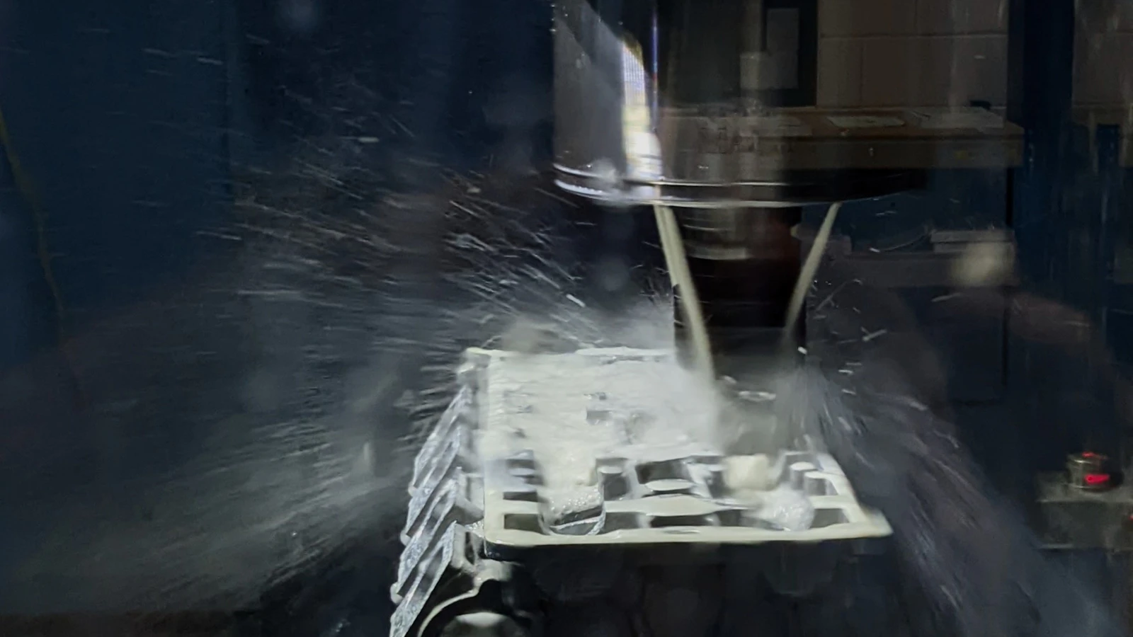 Coolant spraying around a machining tool and workpiece.