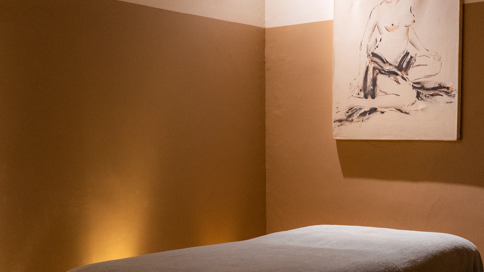 A spa treatment bed beneath abstract wall art.
