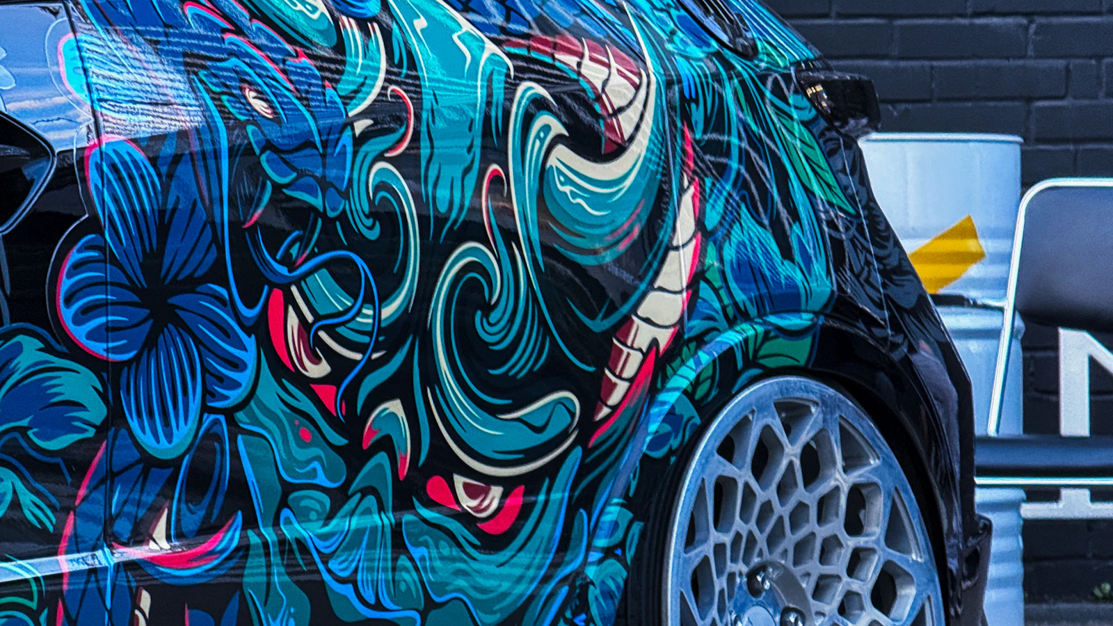 The side of a vehicle with a detailed blue and green dragon graphic.