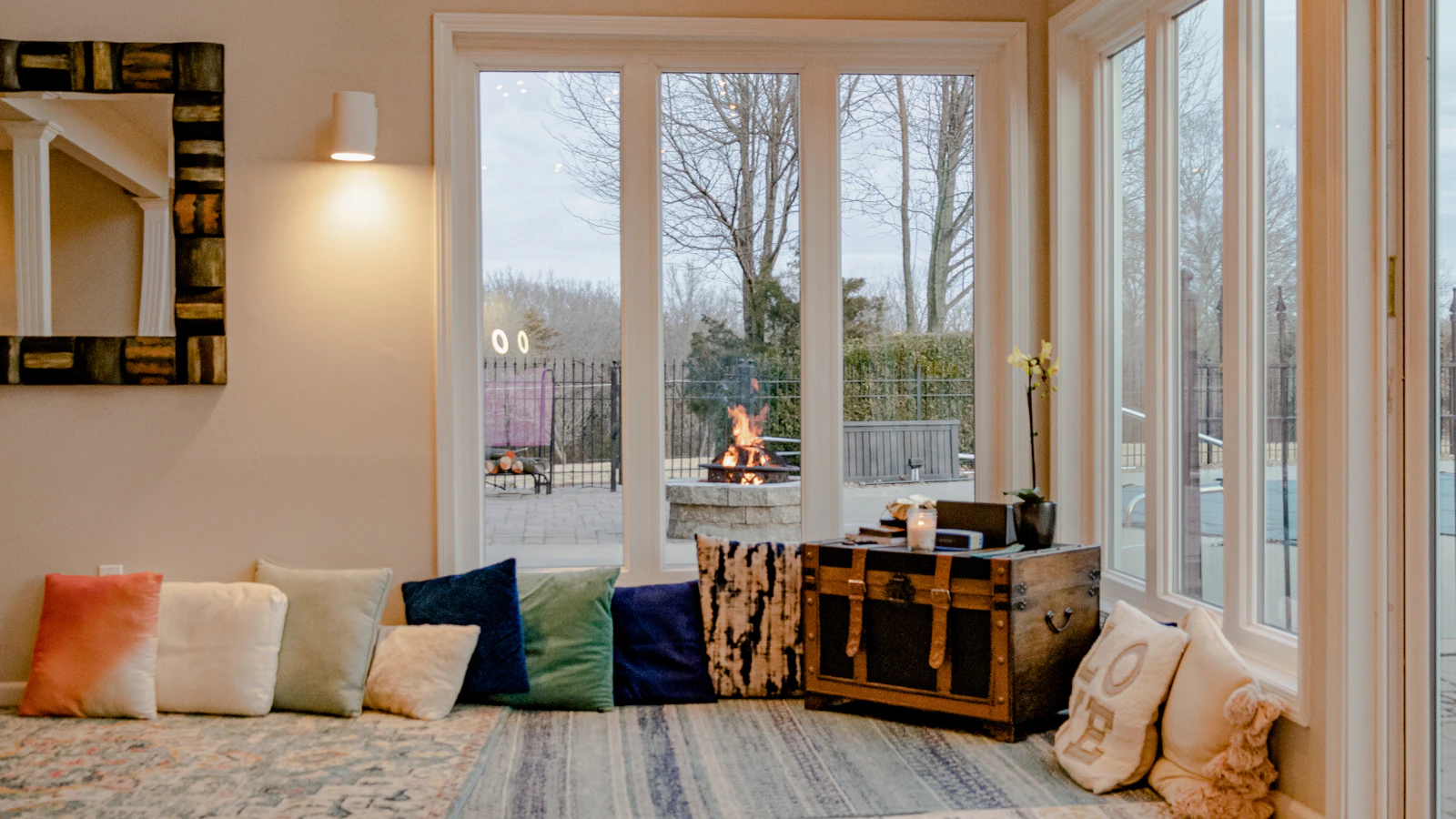 Floor cushions arranged around a low table beside a large window.
