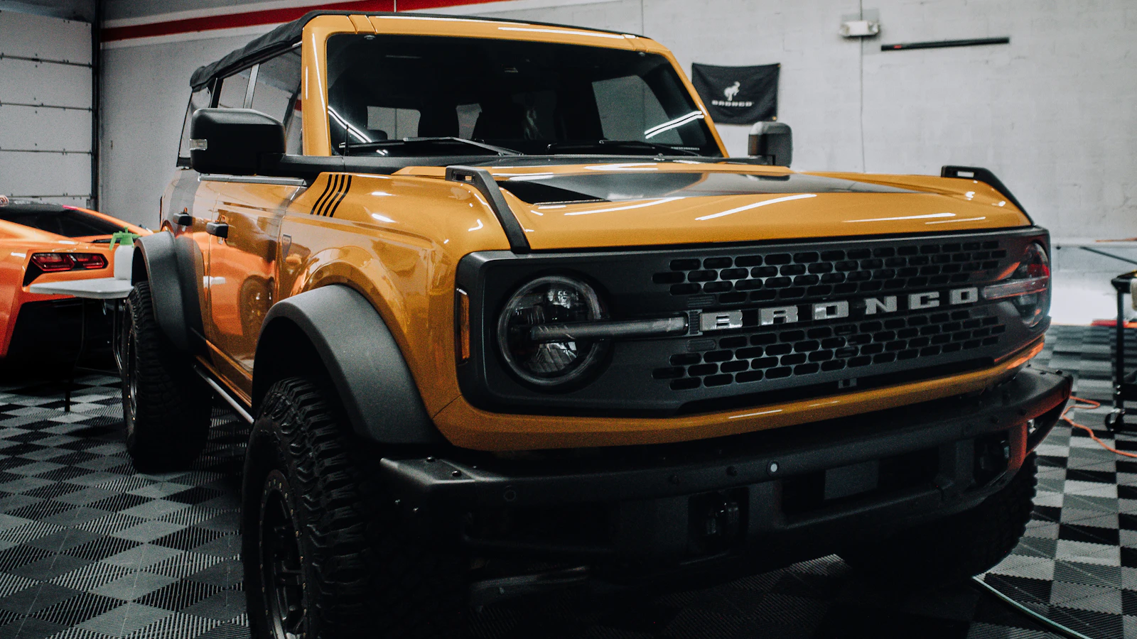 A yellow vehicle parked inside an automotive workshop.