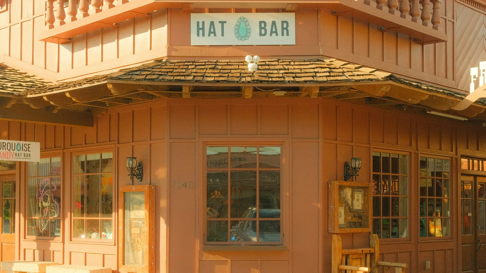 A rustic wooden building with a "hat bar" sign.