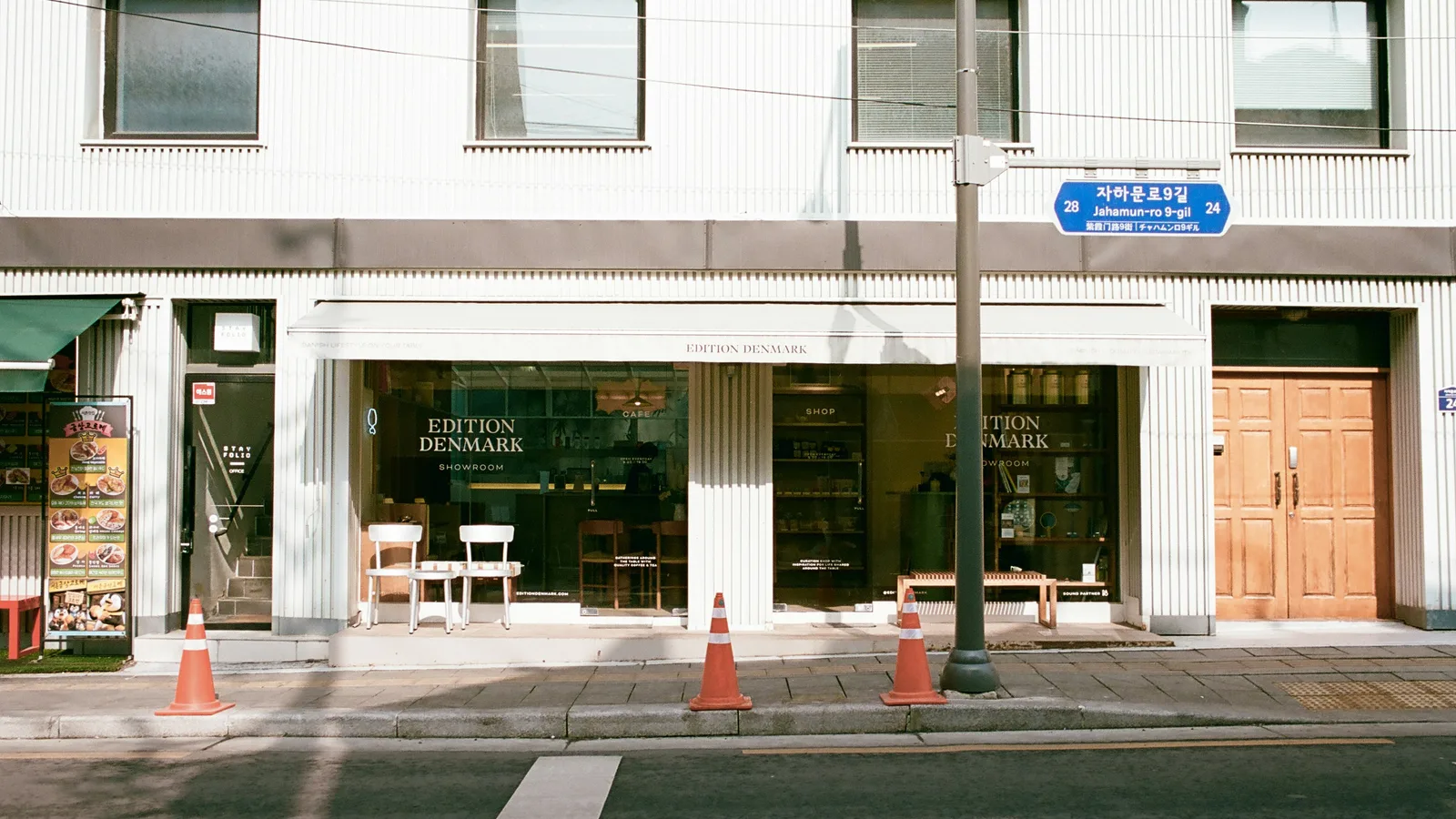 A storefront with large windows and wooden doors.