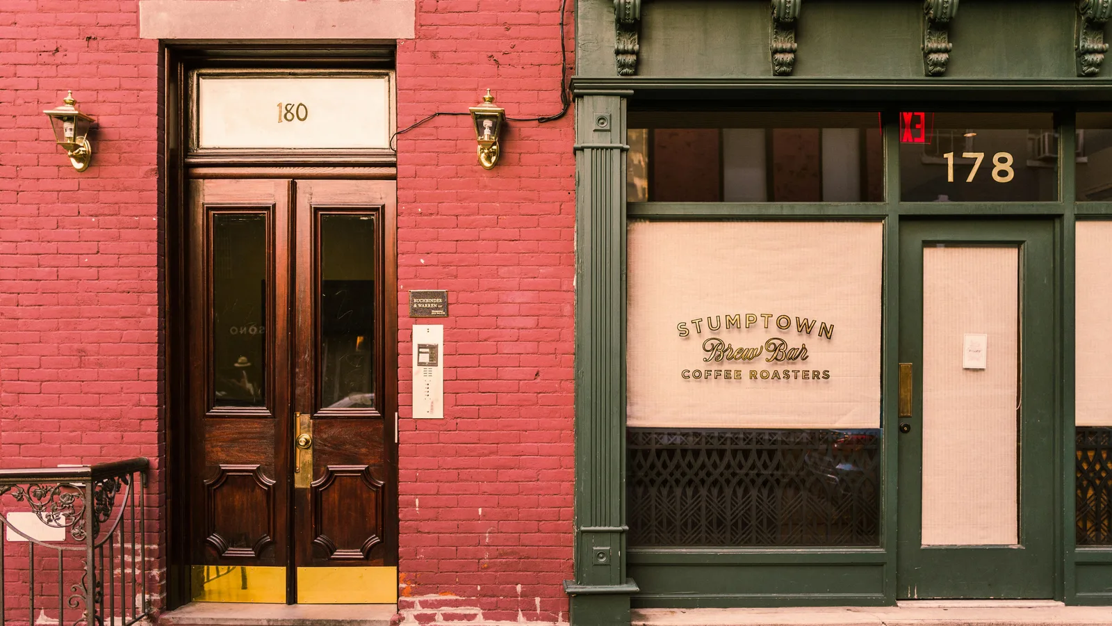 Coffee-shop entrance with green trim and a red brick wall.