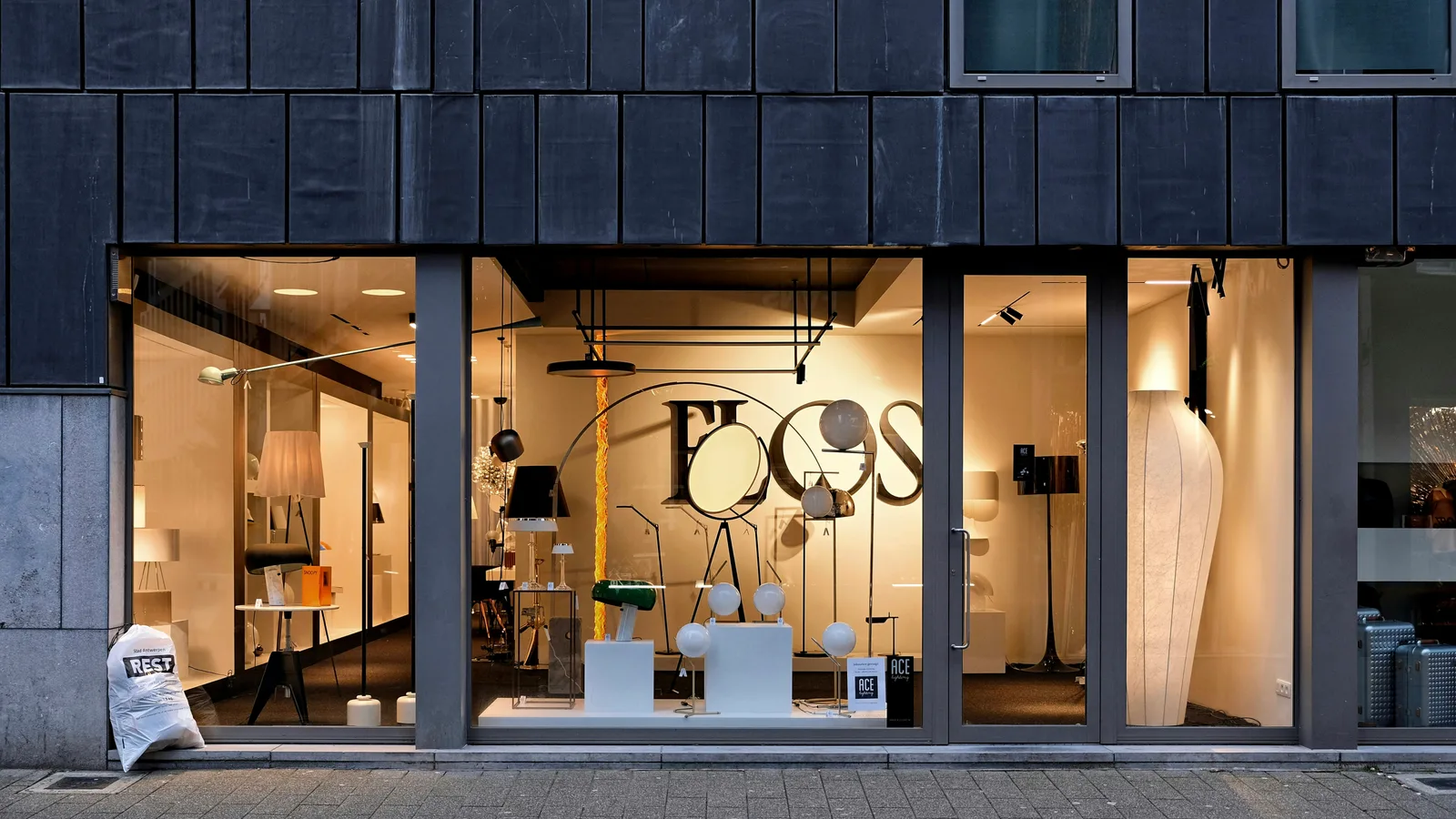 Storefront with large display windows and dark exterior cladding.