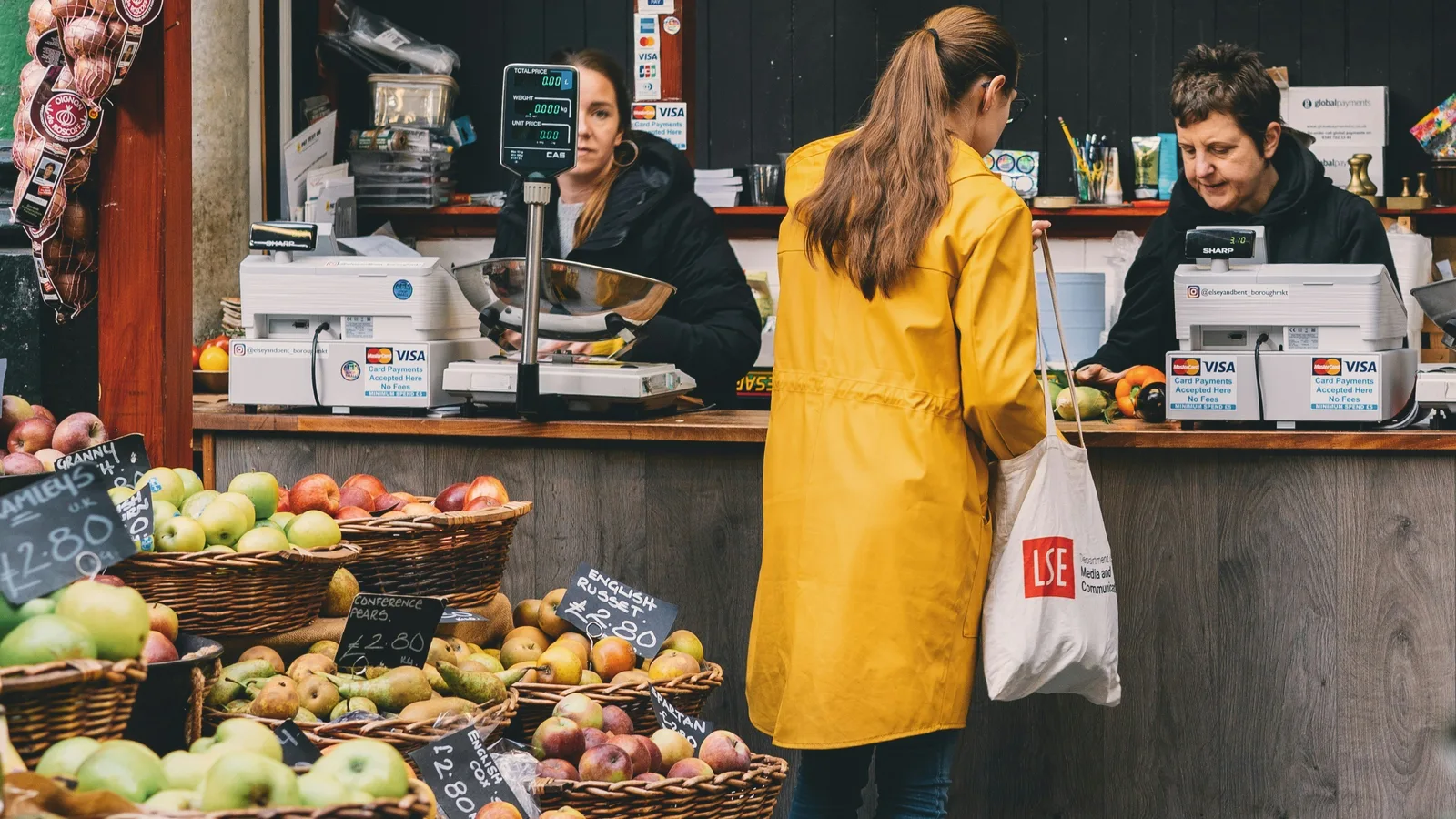 Customer at the checkout counter of a produce shop.