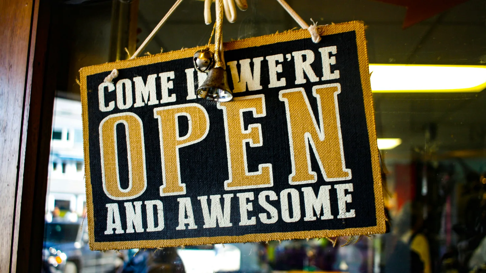 Open sign hanging inside a shop window.