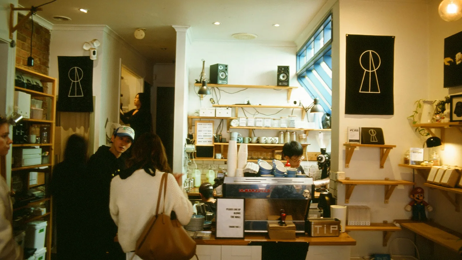 Customers at the counter of a small cafe.