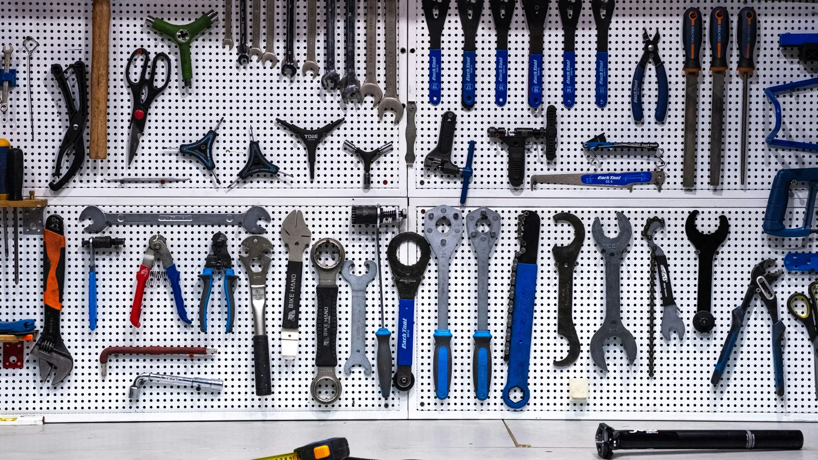 A bunch of tools hanging up on a wall.