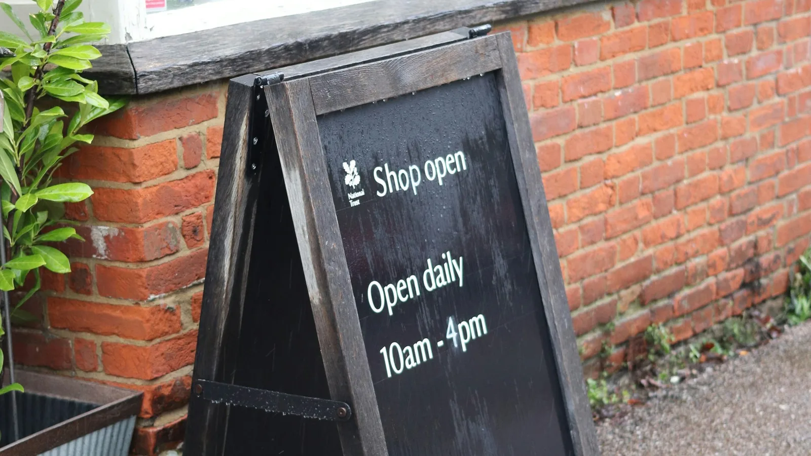 A-frame sign outside a shop showing opening hours.
