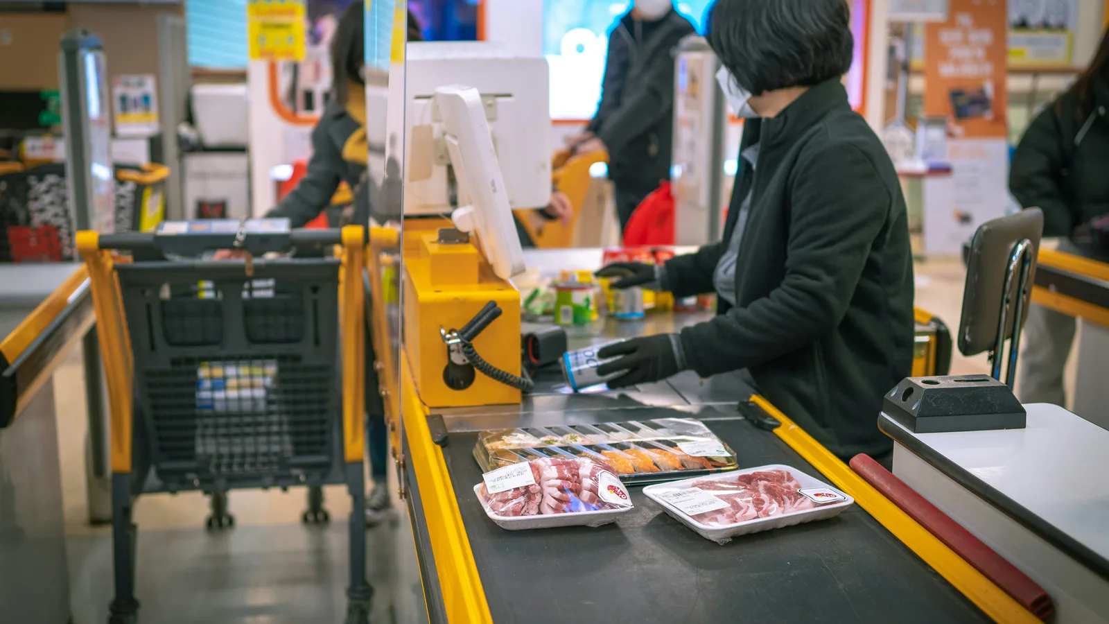 A woman standing at a cash register in a store.