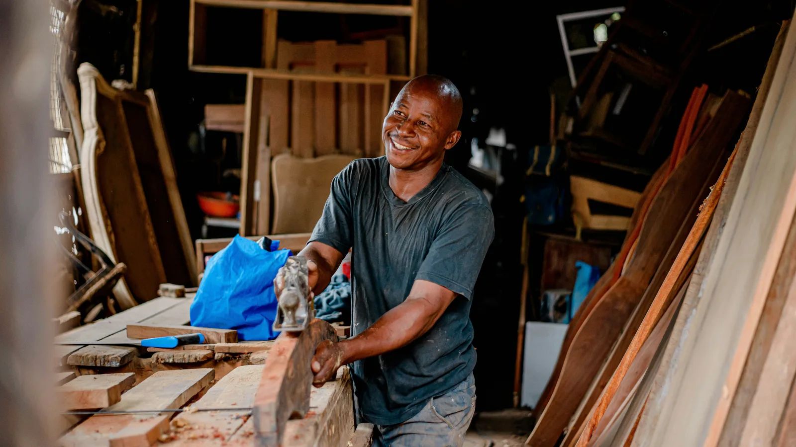 Man working on a piece of wood at a workshop bench.