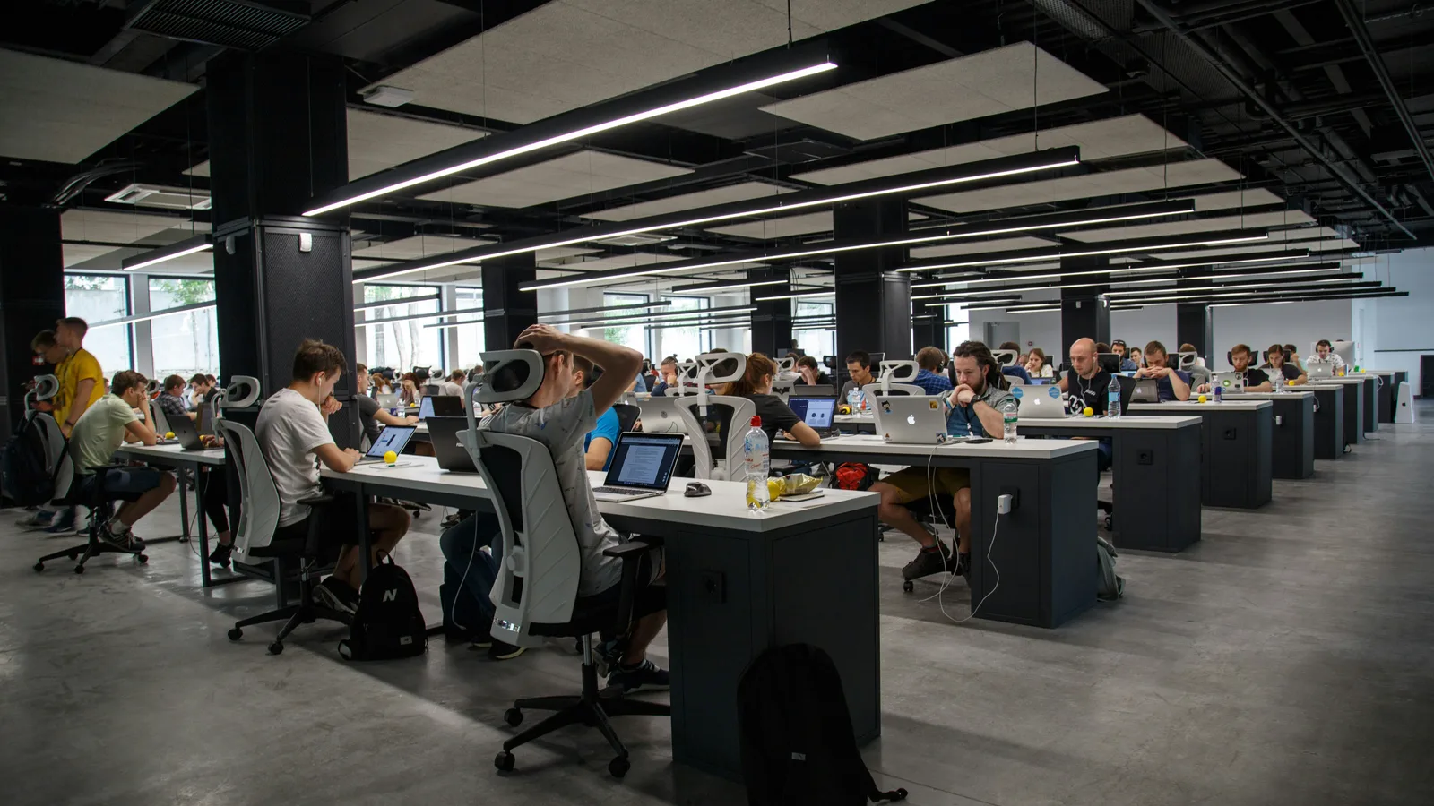 People working at computer desks in an open-plan office.