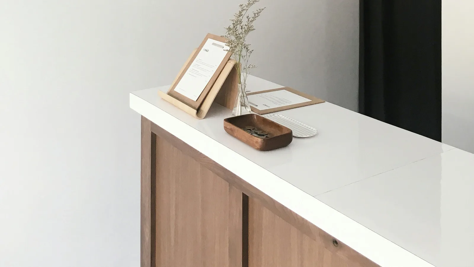 Small wooden counter with a framed notice and a plant.