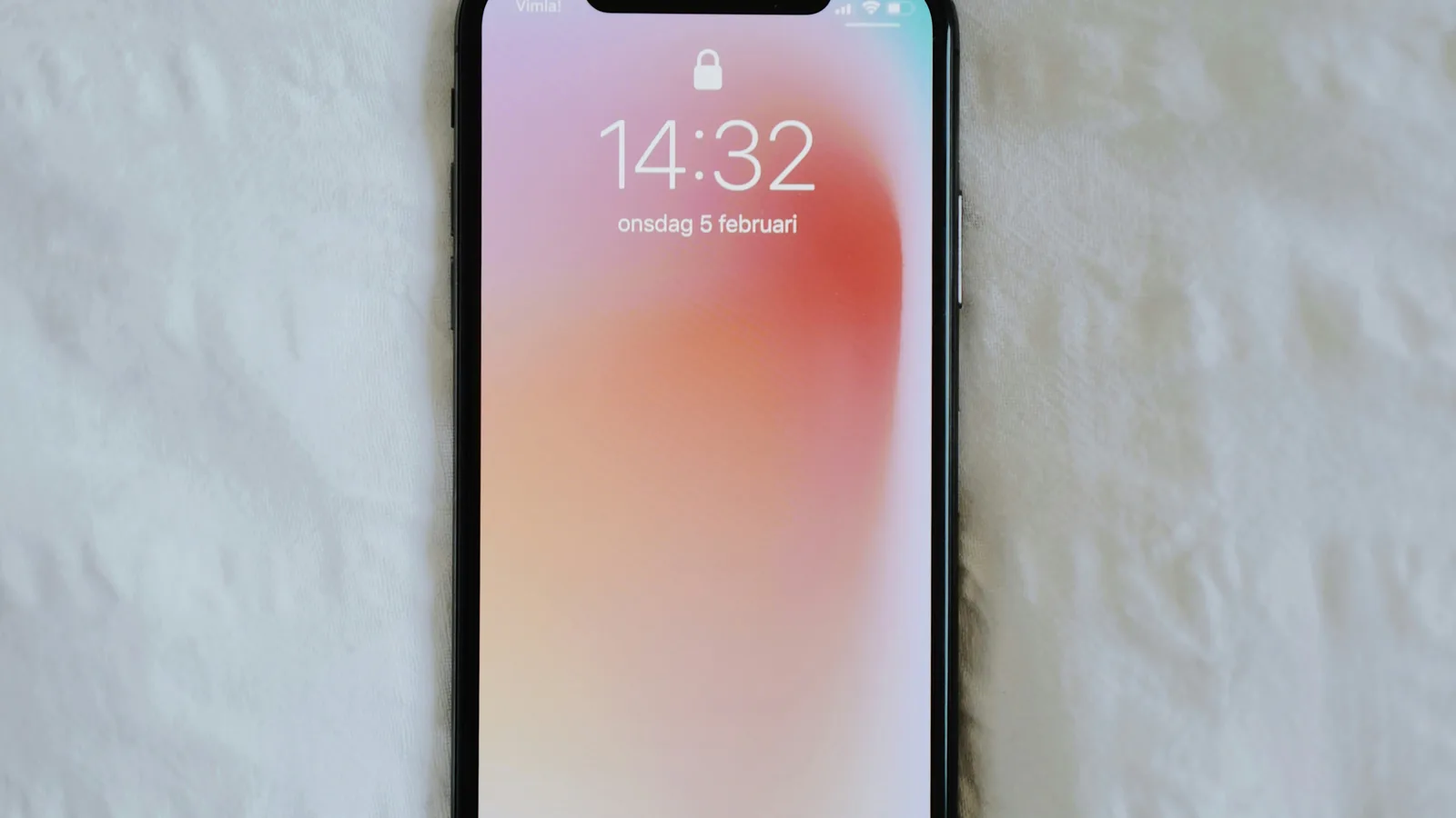 Smartphone lock screen showing the time on a white surface.