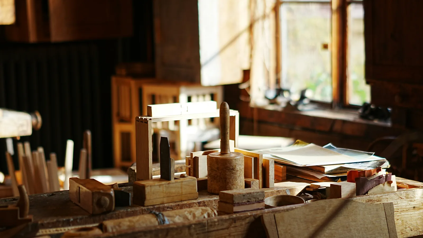 Wooden components and tools on a sunlit workshop bench.