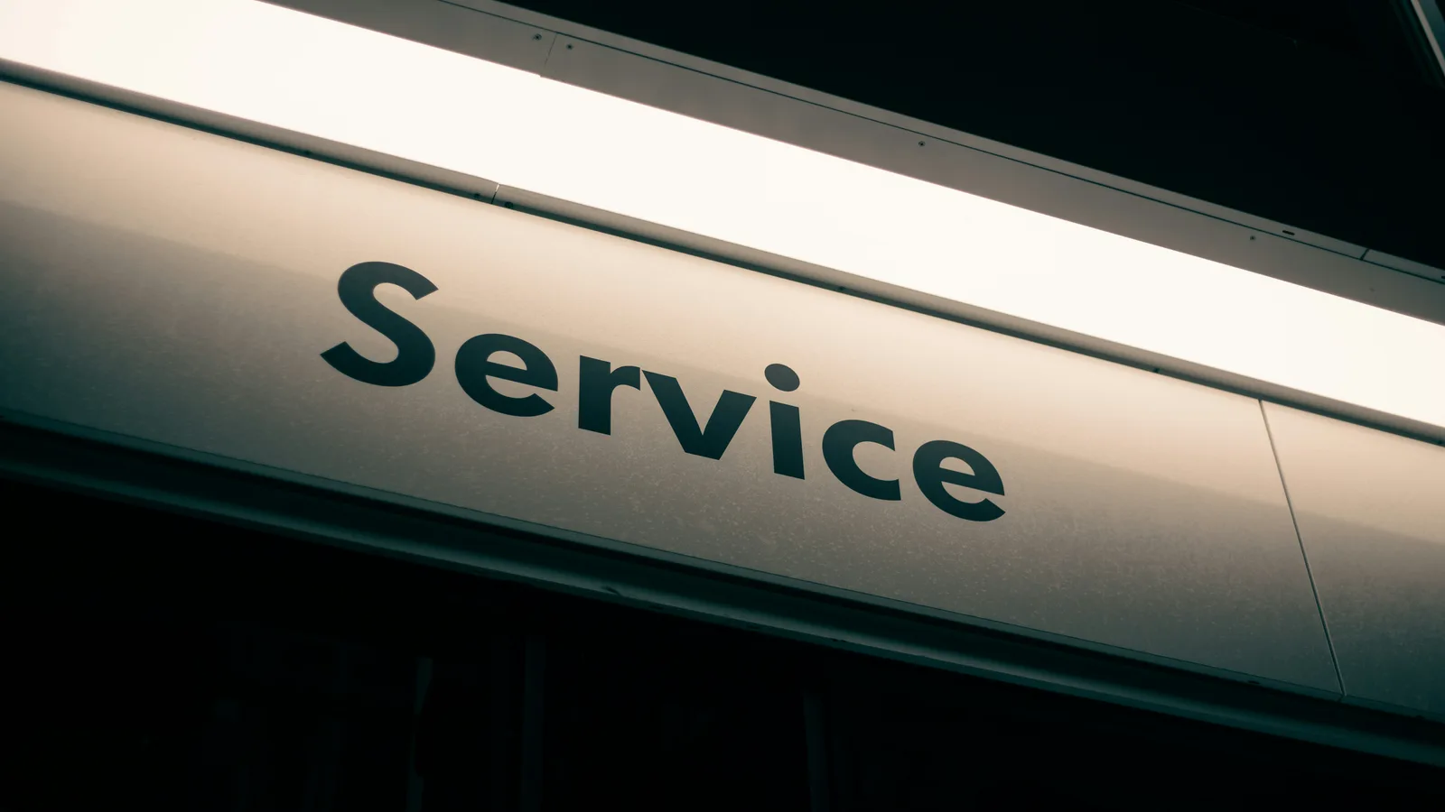 A sign with the word Service in black letters on a white background.