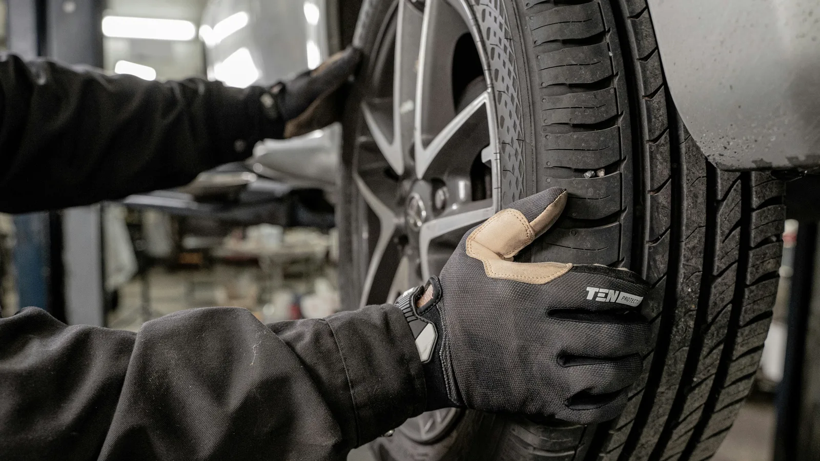 A man working on a tire in a garage.