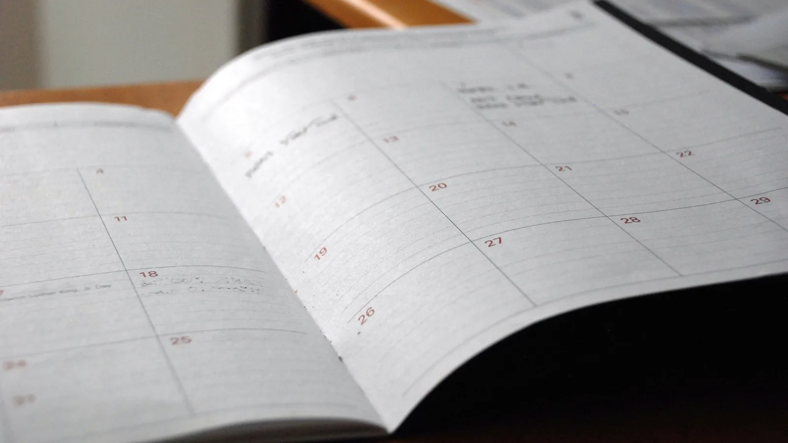 Open monthly planner on wooden desk.