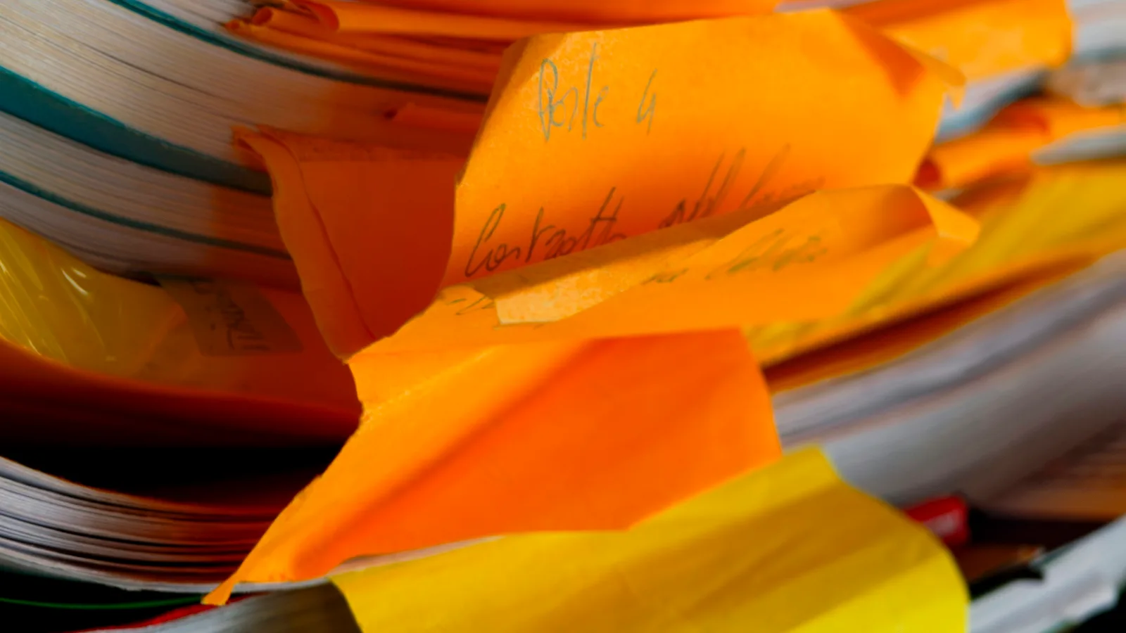 A close-up of a messy stack of papers and files.
