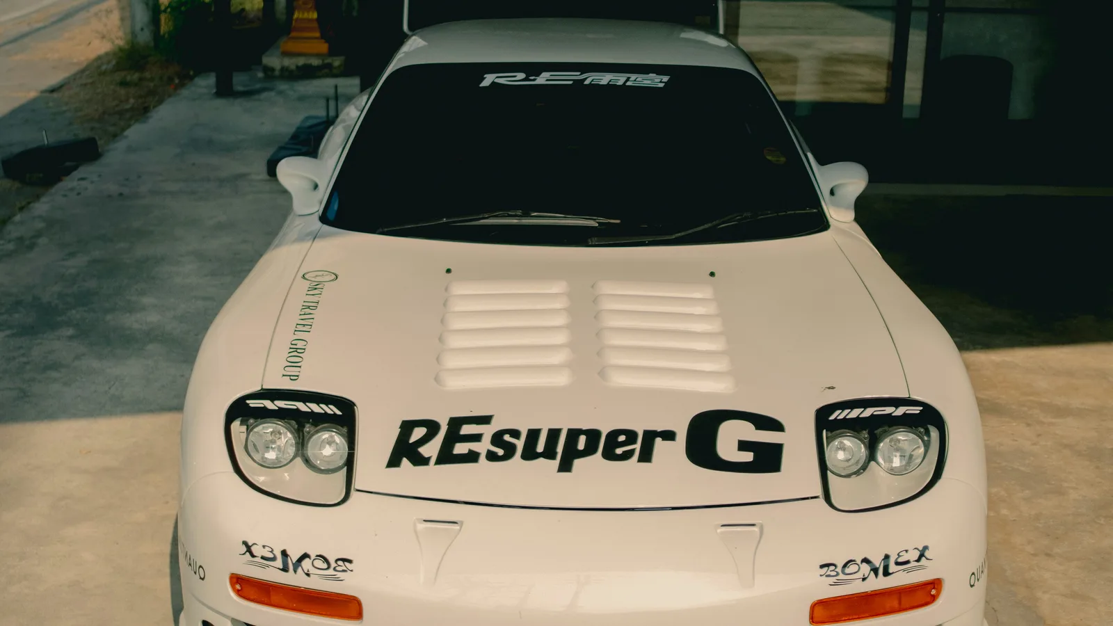 White sports car with racing decals in garage.