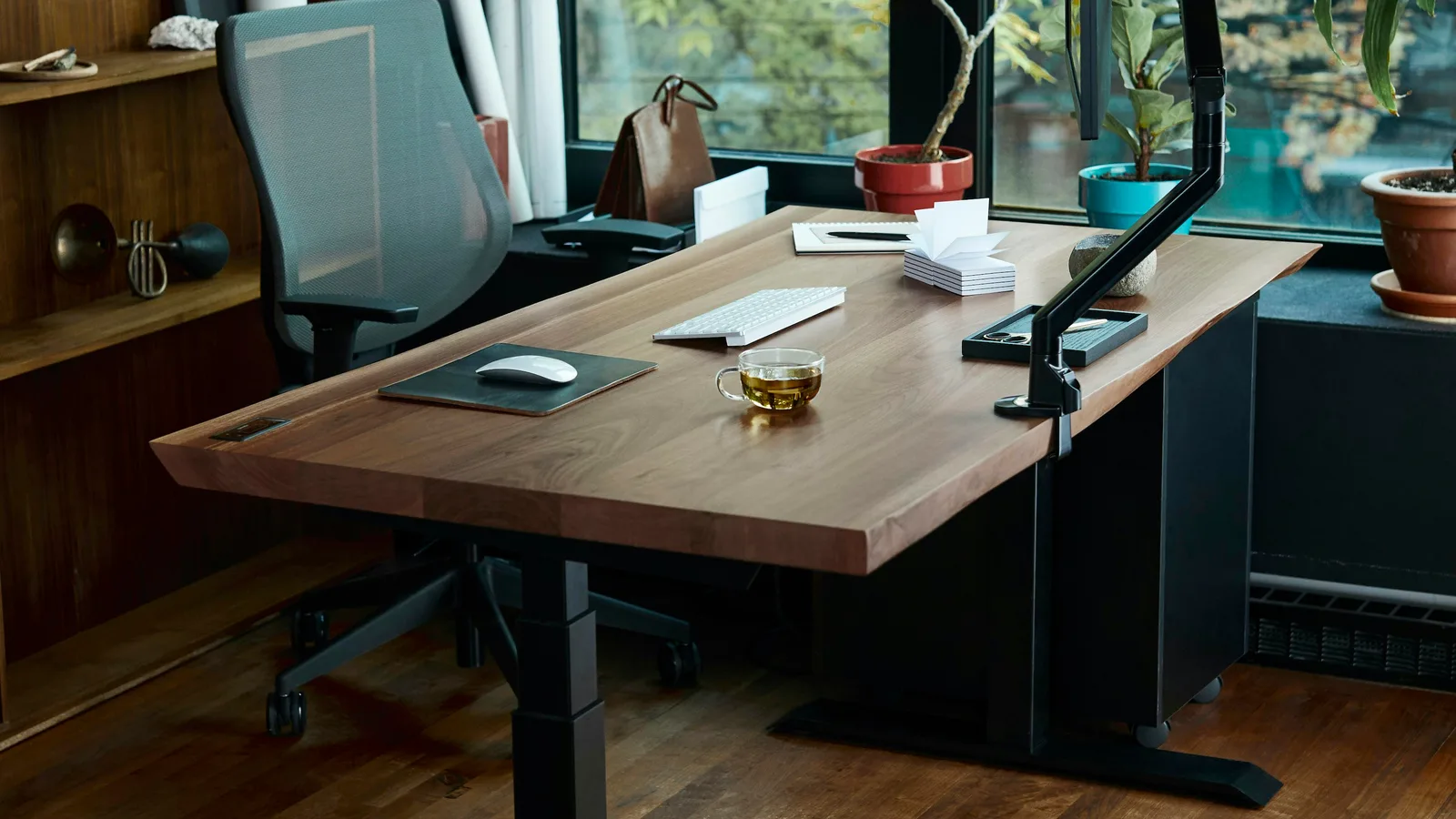 A wooden standing desk with a computer monitor and keyboard in a home office.