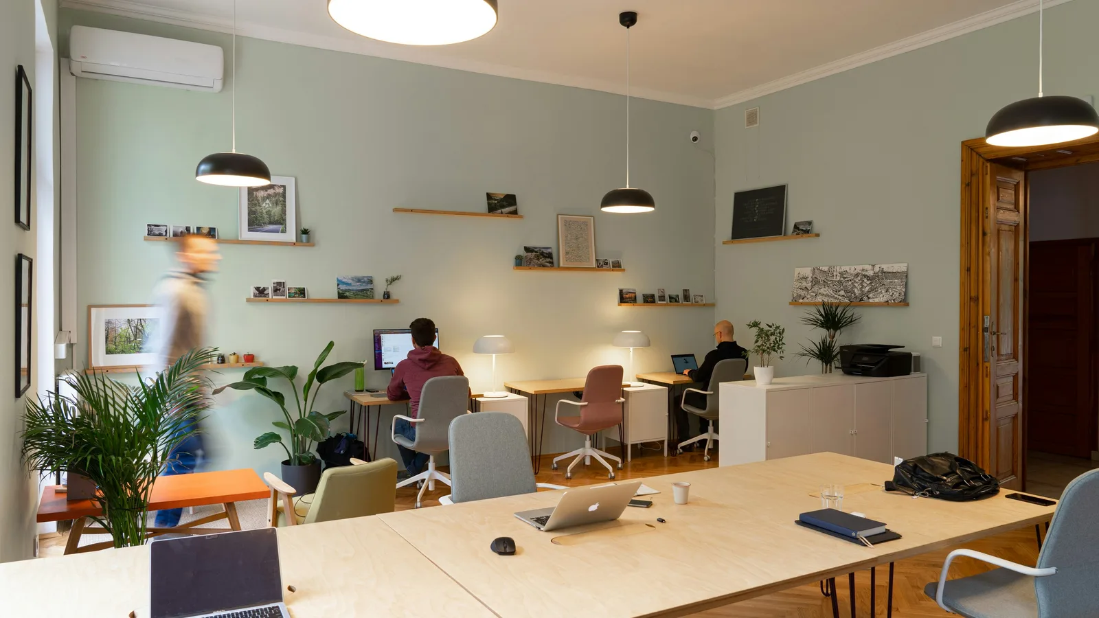 People working at desks in a small shared office.