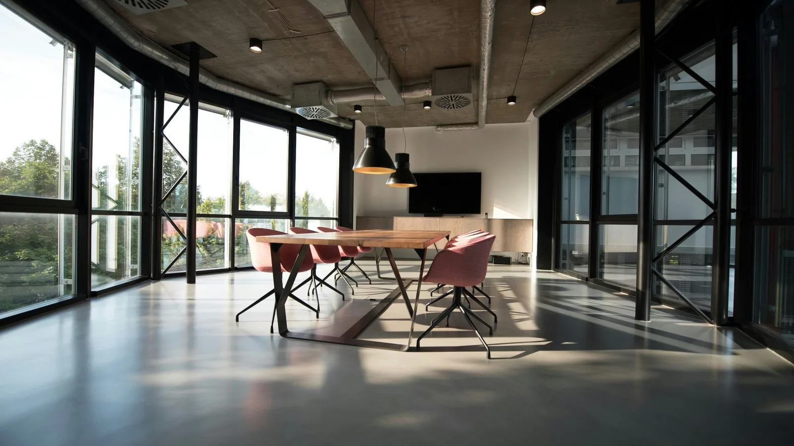 Meeting table and chairs in a glass-walled office.