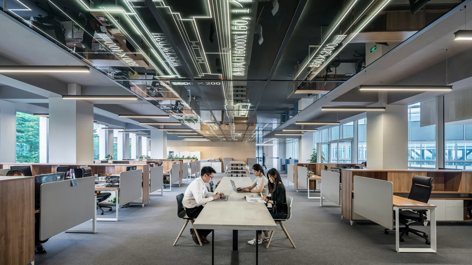 Three people collaborating in open office.