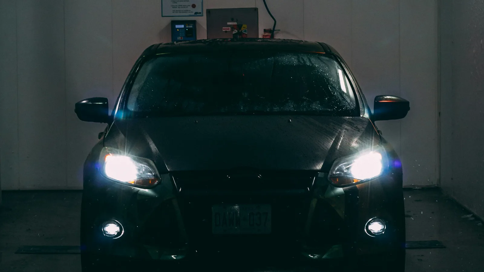 A car is parked in a dark garage.