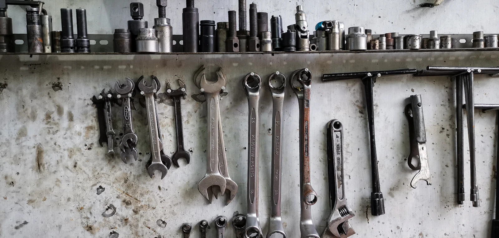 Organized wrenches and sockets on a workshop wall